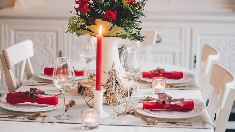 Tavola di Natale decorata con centrotavola, candele e addobbi natalizi eleganti