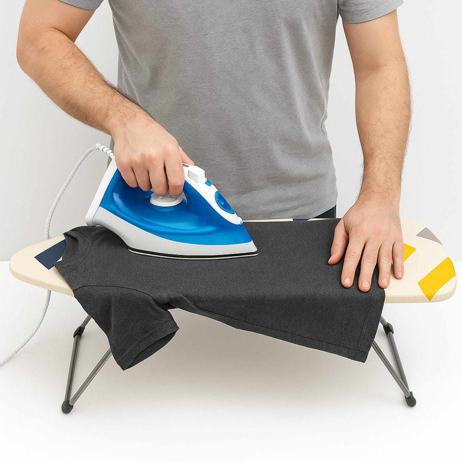 asse-da-stiro-coreografica Persona che stira una maglietta su mini asse da stiro da tavolo Paluplus