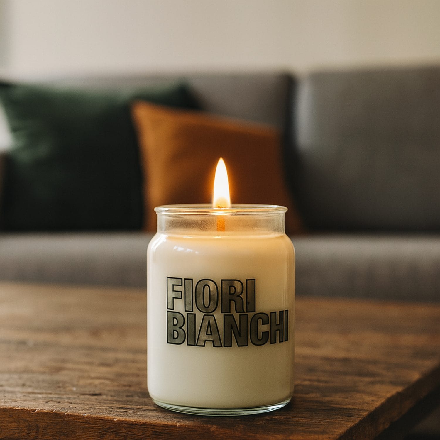 candele in giara coreografica Candela in giara Fiori Bianchi accesa appoggiata su tavolino in salotto moderno