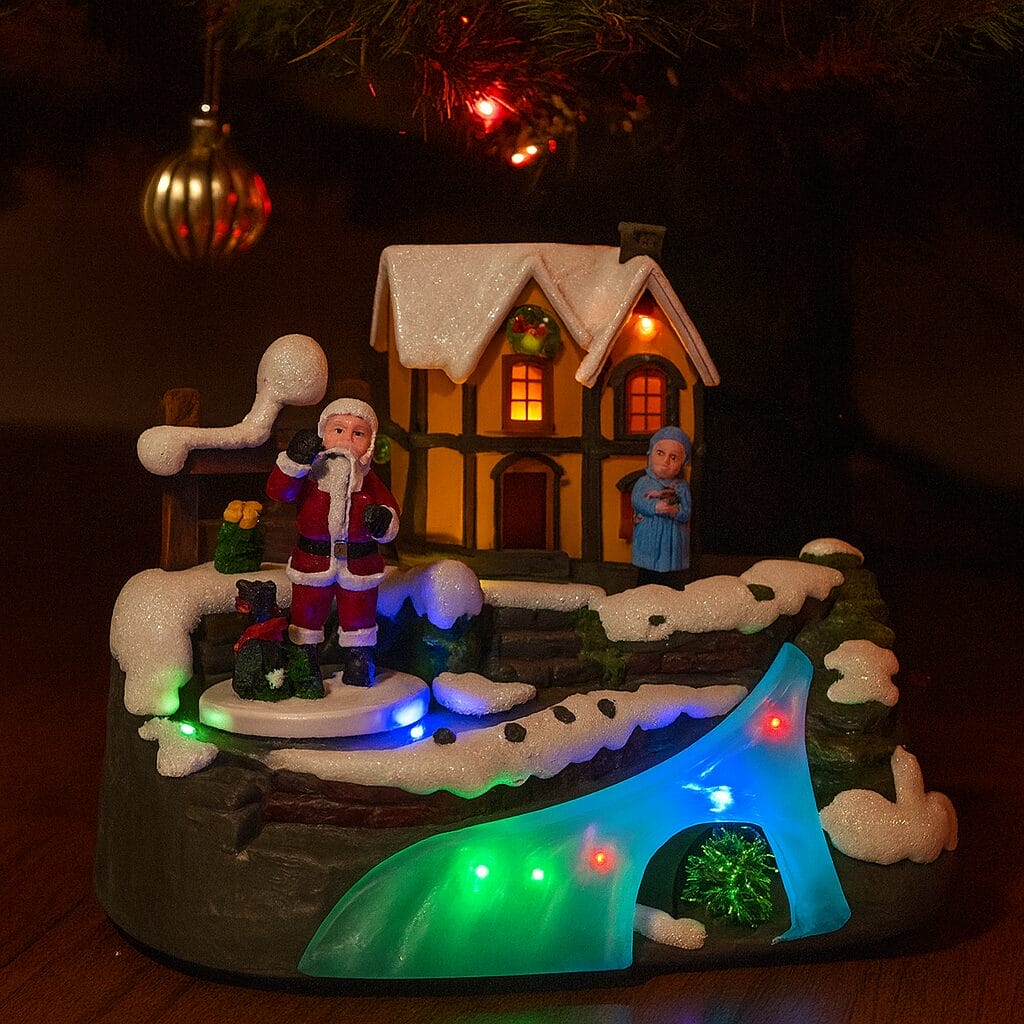 villaggio natalizio luminoso con Babbo Natale, casa innevata e luci LED multicolore