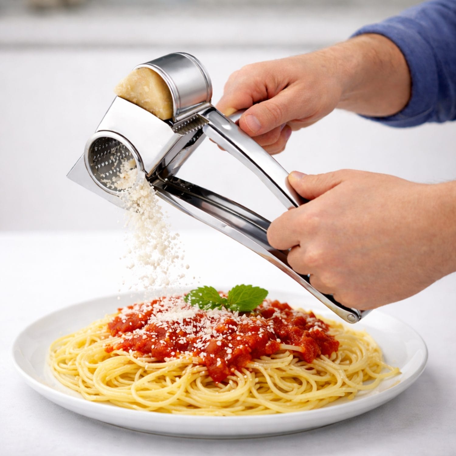 grattugia manuale Grattugia manuale in acciaio inox in uso su pasta con formaggio grattugiato