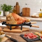 portaprosciutto coreografica Portaprosciutto in legno con prosciutto su tavolo cucina