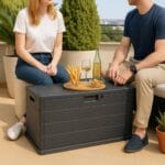 Baule da giardino antracite in resina effetto legno, usato come tavolino da esterno
