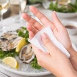 Salvietta rinfrescante al limone per mani dopo pesce su tavolo ristorante