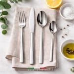 made-in-italy-set-posate-acciaio Set posate in acciaio inox Made in Italy su tovagliolo con forchetta coltello e cucchiai