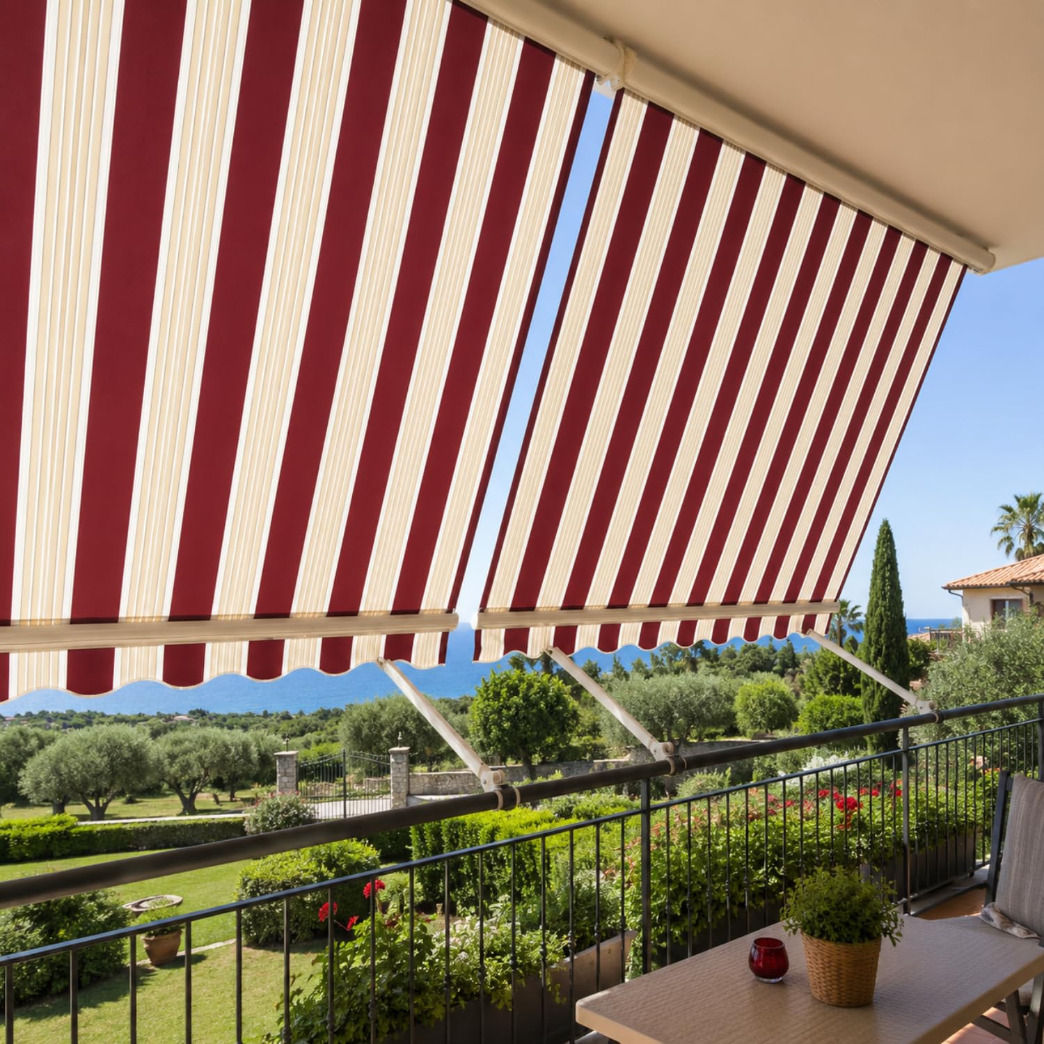 Tenda da sole rigata bordeaux per balconi e terrazzi Tenda da sole a caduta rigata bordeaux e avorio aperta su balcone con bracci fermatenda e vista panoramica