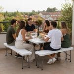 Set tavolo con panche pieghevoli utilizzato per pranzo all’aperto in terrazza con amici