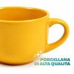Tazza da latte gialla in porcellana resistente Dettaglio ravvicinato di tazza da latte gialla in porcellana lucida con bordo arrotondato e manico ampio
